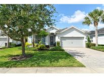 Charming single-story home with a well-manicured lawn, beautiful landscaping, and a paver driveway at 11502 Golden Bay Pl, Bradenton, FL 34211