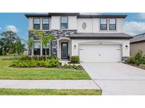 Charming two-story home features stone accents, a two-car garage, and a beautifully landscaped front yard at 14787 Gallop Run Dr, Lithia, FL 33547