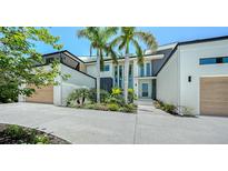 Stunning contemporary home featuring a clean white facade, palm trees, and lush landscaping at 1607 Flower Dr, Sarasota, FL 34239