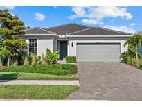Charming single-story home with well-manicured landscaping, brick driveway, and a two-car garage at 26000 Seastone Dr, Englewood, FL 34223