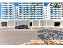 Apartment entrance featuring a light gray car parked out front, a textured white fence and a flagpole at 33 S Gulfstream Ave # 306, Sarasota, FL 34236