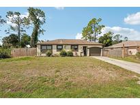 Charming single-story home featuring a well-maintained lawn, attached garage, and neutral color palette at 3881 Holin Ln, North Port, FL 34287