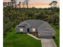 Charming single-story home featuring a well-manicured lawn and a two-car garage at 4091 Dull St, North Port, FL 34286