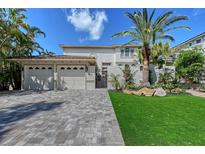 Charming two-story home with a three-car garage, tiled roof, and tropical landscaping at 4108 Roberts Point Rd, Sarasota, FL 34242