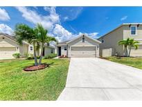 Charming one-story home featuring a well-manicured lawn, a two-car garage, and a freshly sealed concrete driveway at 4206 Park Willow Ave, Palmetto, FL 34221