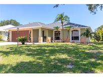 Charming single-story home featuring a well-manicured lawn and lush landscaping with decorative stone accents at 4758 Breezy Pines Blvd, Sarasota, FL 34232