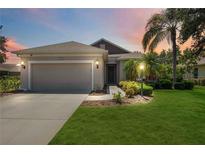 Charming single-story home featuring a well-manicured lawn, two-car garage, and inviting curb appeal at 5020 Torrey Pines Run, Bradenton, FL 34211
