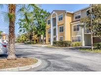 Inviting yellow condo building showcasing manicured landscaping and ample parking space at 5552 Bentgrass Dr # 7-301, Sarasota, FL 34235