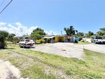 Charming single-story home with a bright yellow facade, large parking area, and boat, creating an inviting curb appeal at 616 63Rd W Ave, Bradenton, FL 34207