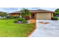 Charming single-story home featuring a well-manicured lawn, lush landscaping, and a two-car garage at 8402 13Th Nw Ave, Bradenton, FL 34209