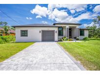 Charming single Gathering home featuring a stone driveway, a two-car garage, and well manicured landscaping at 11960 De Leon Dr, North Port, FL 34287