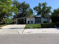 Charming single-story home with modern design elements, mature trees, and a well-maintained front lawn at 1801 Marilyn Ave, Bradenton, FL 34207