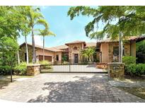 Elegant single-Gathering home with a clay tile roof, stone accents, gated entrance and lush landscaping at 1813 Boyce St, Sarasota, FL 34239