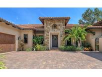 Stunning Mediterranean home featuring a stone facade, tile roof, and meticulously landscaped front yard at 1813 Boyce St, Sarasota, FL 34239