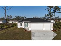Charming single-story home features a three-car garage, well-maintained lawn, and a modern design at 2323 Zuyder Ter, North Port, FL 34286