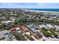 Stunning aerial view of a waterfront property with lush landscaping and a peek of the ocean at 30 Island Cir, Sarasota, FL 34242