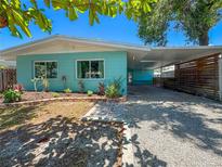 Charming turquoise home featuring a covered carport and well-maintained landscaping at 302 Pavonia Rd, Nokomis, FL 34275
