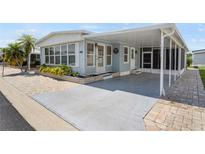 Charming single-story home featuring a covered parking area, quaint front garden, and brick-paved pathways at 3214 Sycamore Ter, Sarasota, FL 34237