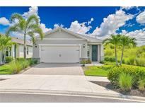 Beautiful single-story home with a two-car garage, lush landscaping, and a welcoming front entrance at 42250 Ramble Rd, Punta Gorda, FL 33982