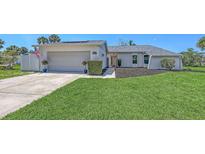 Charming home featuring a two-car garage, meticulously landscaped front yard, and an inviting walkway to the front door at 4308 Kingston Loop, Sarasota, FL 34238