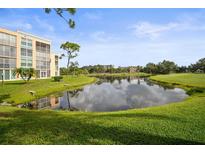 Scenic view of a pond reflecting the sky, surrounded by lush green grass and landscaping near the building at 4530 Pinebrook Cir # 109, Bradenton, FL 34209