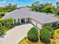 An aerial view of the home shows an expansive roofline, three-car garage and a well-manicured lawn at 5373 Anthony Ln, Sarasota, FL 34233