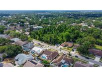 Beautiful aerial view of a home with a screened pool and lush landscaping in a desirable neighborhood at 5613 Sweetwater Oak Dr, Sarasota, FL 34232
