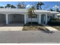 Charming villa featuring a covered parking area, tropical landscaping, and a cozy entrance at 669 Spanish N Dr # 21, Longboat Key, FL 34228