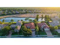 Aerial view of a beautiful home with a tile roof, situated on a golf course with a scenic lake view at 6914 Dominion Ln, Lakewood Ranch, FL 34202