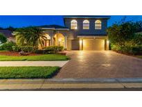 Stunning two-story home features a brick driveway, three car garage, and mature landscaping at 9008 Brookfield Ter, Bradenton, FL 34212