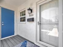 Inviting front entrance with blue door, decorative rug, and charming exterior lighting, enhancing curb appeal at 9822 Desoto Ct, Bradenton, FL 34210