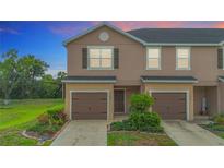 Charming townhome featuring a well-maintained lawn, garage, and inviting curb appeal at 1053 Grantham Dr, Sarasota, FL 34234