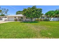 Charming single-story home with a well-manicured lawn and mature shade tree at 1324 Augusta S Ln, St Petersburg, FL 33707