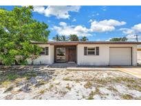 Charming single-story home features a one-car garage and a simple front landscape at 310 Avenida Milano, Sarasota, FL 34242