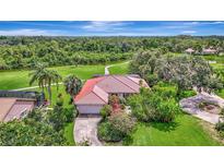 Charming single-story home featuring a red tile roof, lush landscaping, and a private driveway, nestled among mature trees at 3388 Highlands Bridge Rd, Sarasota, FL 34235
