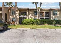 Inviting condo exterior with well-maintained landscaping, balconies, and assigned parking spaces at 4061 Crockers Lake Blvd # 27, Sarasota, FL 34238