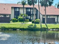 Exterior view of this two-story home with balcony and lush landscaping on a pond at 5400 34Th W St # H12, Bradenton, FL 34210