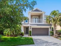 Beautiful two-story home with a charming balcony, two-car garage, and manicured lawn at 5709 Wild Sage Cir, Sarasota, FL 34238