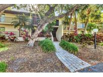 Inviting condo building with lush landscaping and a charming walkway leading to the entrance at 6501 Mourning Dove Dr # 215, Bradenton, FL 34210