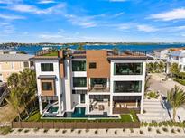 Stunning three-story home boasting a private pool, jacuzzi, and rooftop terrace with panoramic water views at 100 6Th S St, Bradenton Beach, FL 34217
