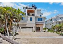 Beautiful three-story home with multiple balconies, a garage, and lush tropical landscaping at 135 Avenida Veneccia, Sarasota, FL 34242