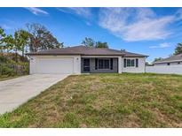 Charming single-story home with a two-car garage and a well-maintained front lawn at 1370 Mccrory St, North Port, FL 34286
