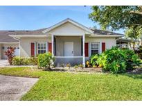 Charming single-story home with a well-maintained lawn, complemented by vibrant greenery and a cozy, covered entryway at 1516 Red Oak Ln, Port Charlotte, FL 33948