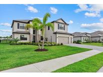 Beautiful two-story home with a well-manicured lawn and lush landscaping under a cloudy sky at 15315 Golden Beam Pl, Bradenton, FL 34211