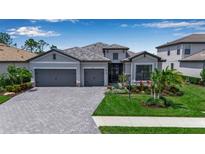 Charming single-story home with a three-car garage, paver driveway and walkway, and well-maintained landscaping at 15607 White Linen Dr, Bradenton, FL 34211
