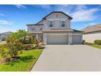Charming two-story home with a three car garage, manicured lawn and beautiful landscaping at 2332 Mizner Bay Ave, Bradenton, FL 34208