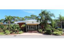 Exterior view of clubhouse with palm trees and tropical landscaping at 2650 Coconut Bay Ln # 521, Sarasota, FL 34237