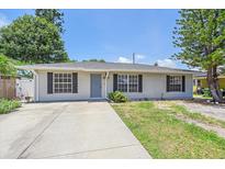 Well-maintained home with a manicured lawn, shutters and a concrete driveway at 2953 Oak St, Sarasota, FL 34237
