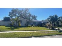 Charming single-story home featuring a well-maintained lawn and mature landscaping at 3054 Lockwood Ter, Sarasota, FL 34231