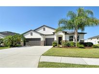 Beautiful single-story home featuring a well-manicured lawn, a three-car garage, and tasteful landscaping at 364 Grande Vista Blvd, Bradenton, FL 34212